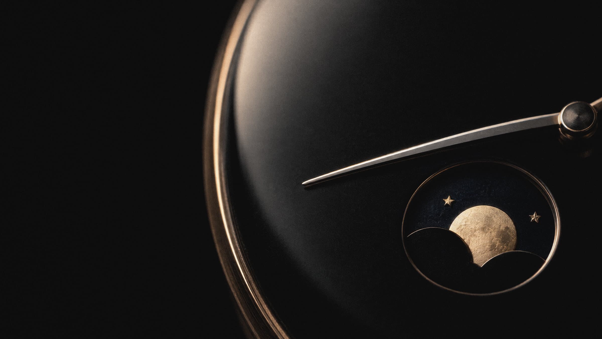 Black enamel dial with a gold moonphase, close-up